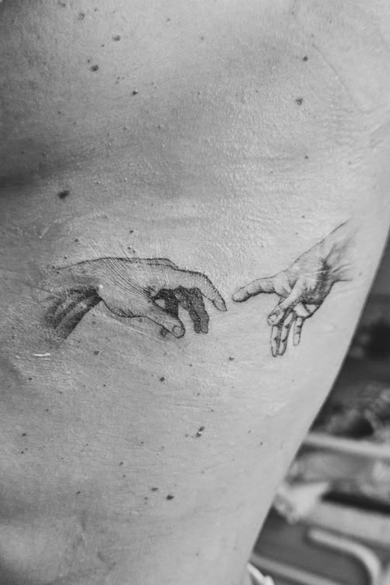 A tattoo of the creation hands