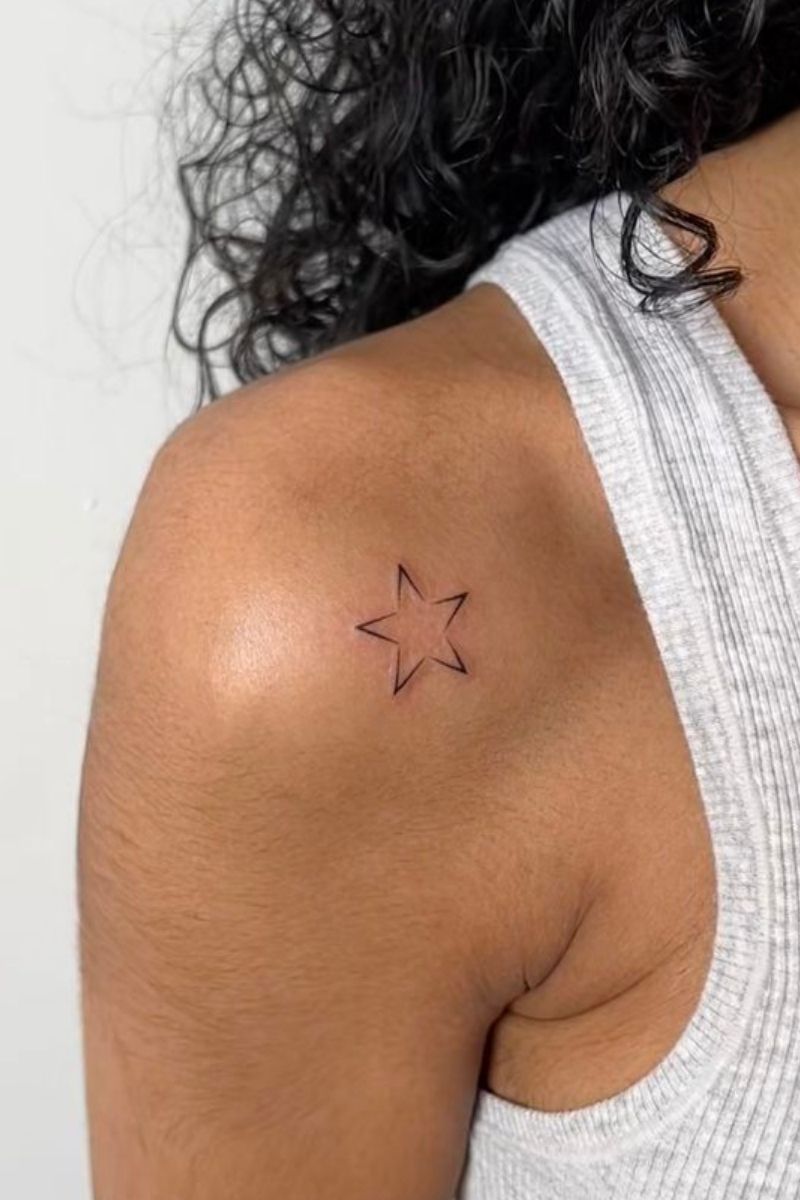 A girl with a tattoo of a star on her arm