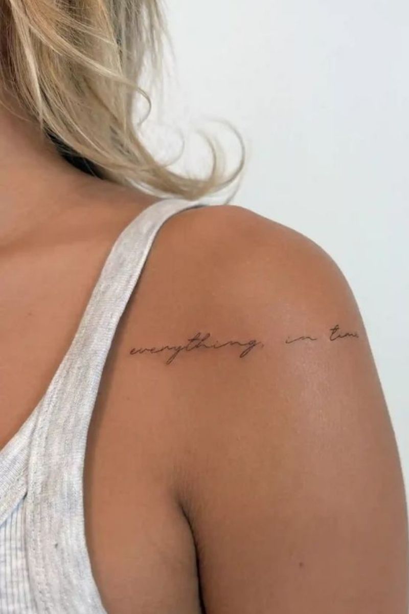 An elegant script tattoo wrapped around a woman's shoulder