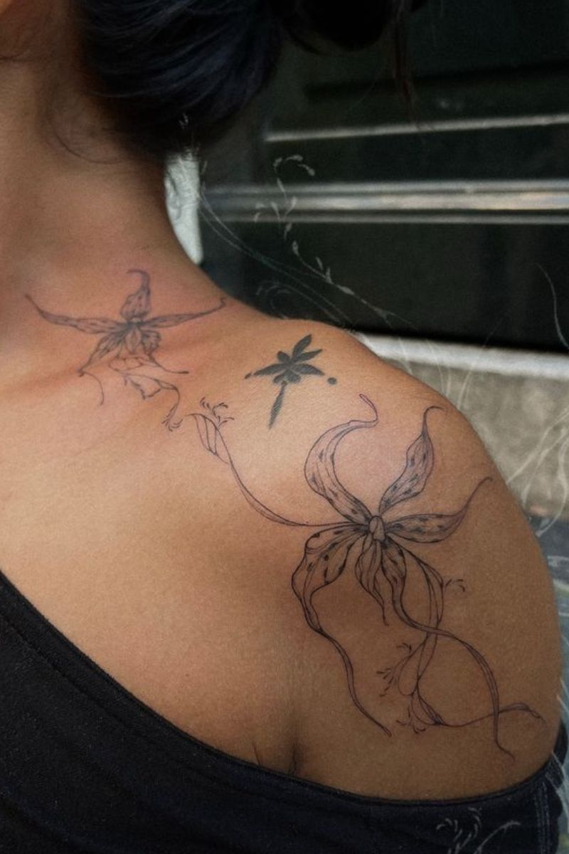 Dancing orchids tattoo on a woman's shoulder.