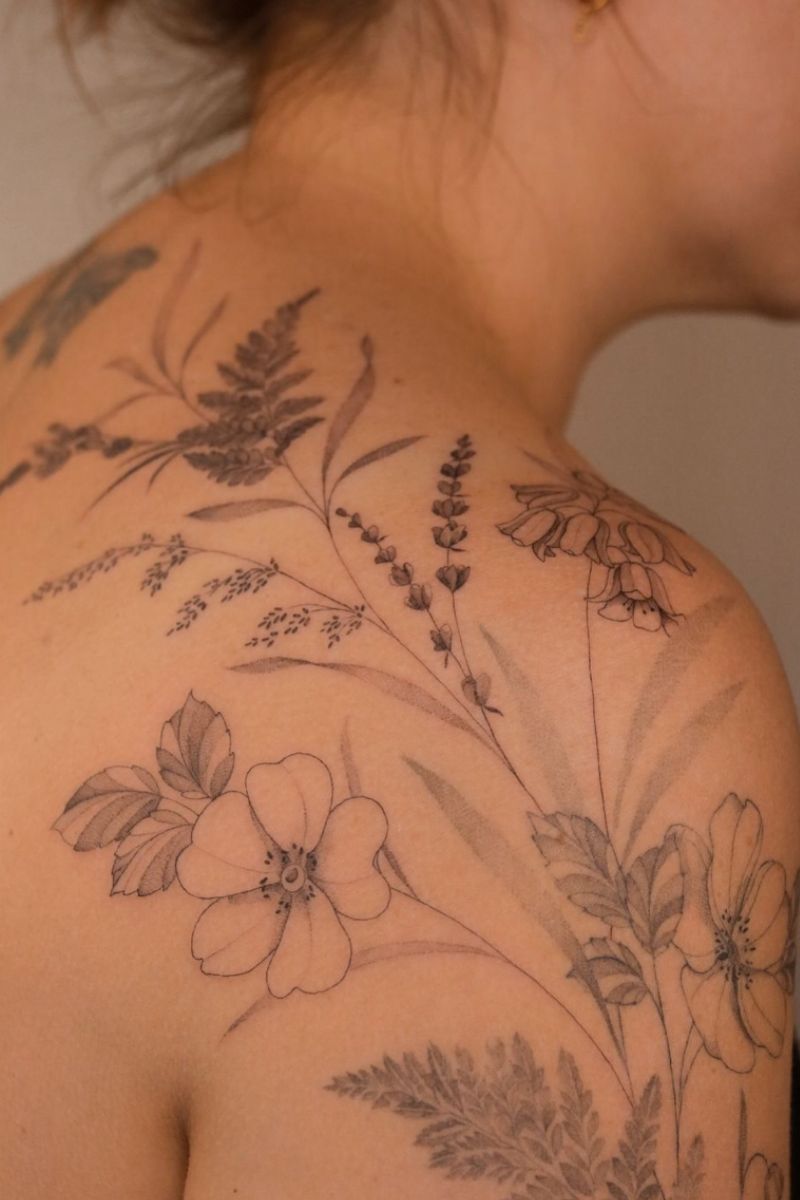 A tattoo of a bundle of wildflowers on a woman's shoulder 
