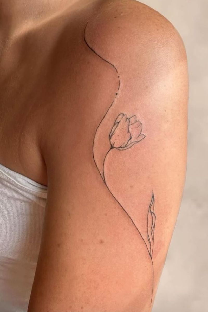 A girl with a tattoo of a flower that wraps her shoulder 